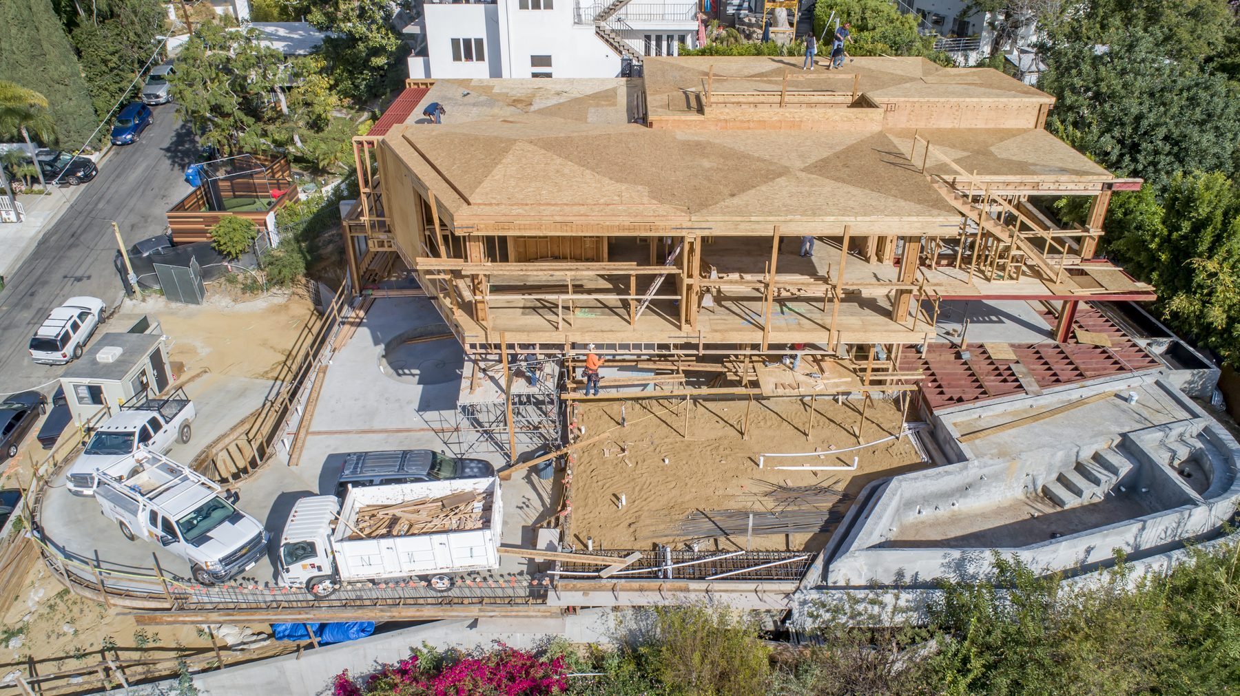 Aerial view of a hillside home rebuild during framing